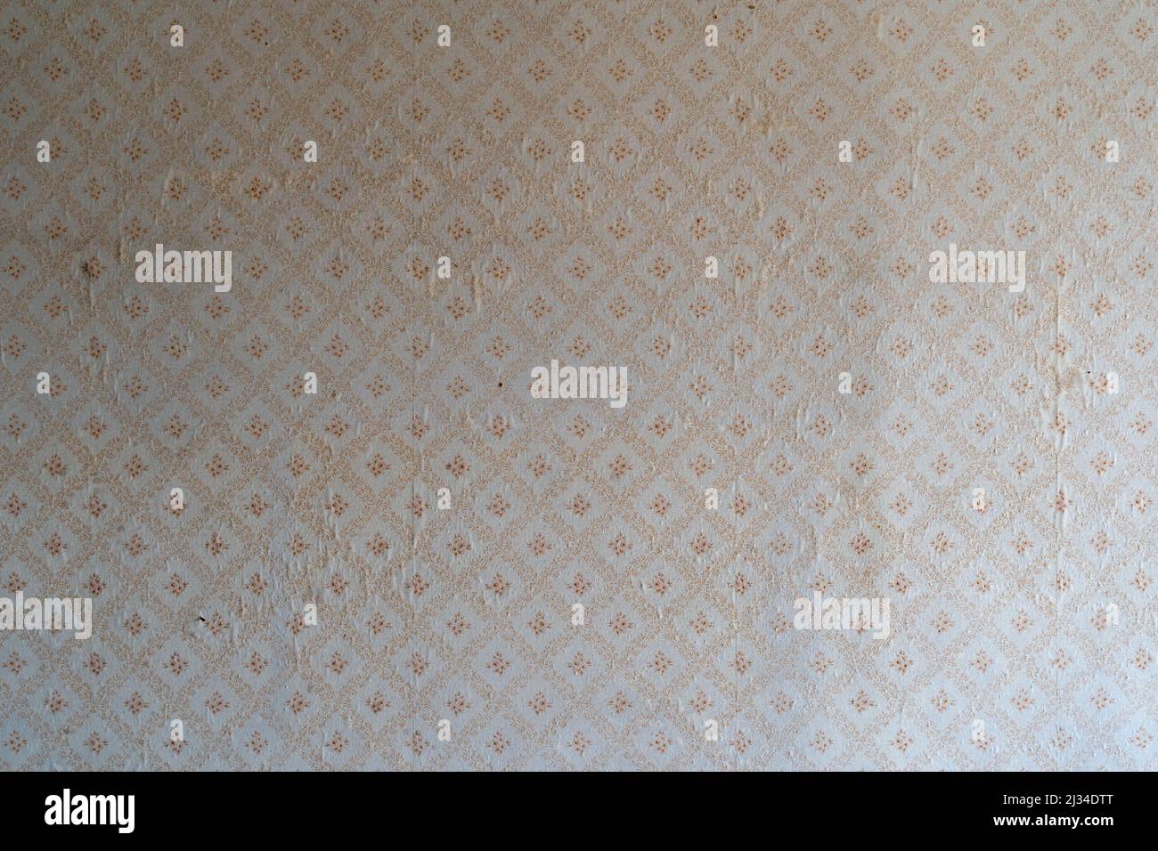 Alte Tapete mit einem Vintage-Blumenmuster. Verwittertes Hintergrundtexturmuster eines beschädigten Materials. Inneneinrichtung eines Retro-Zimmers. Gewellte Wand. Stockfoto