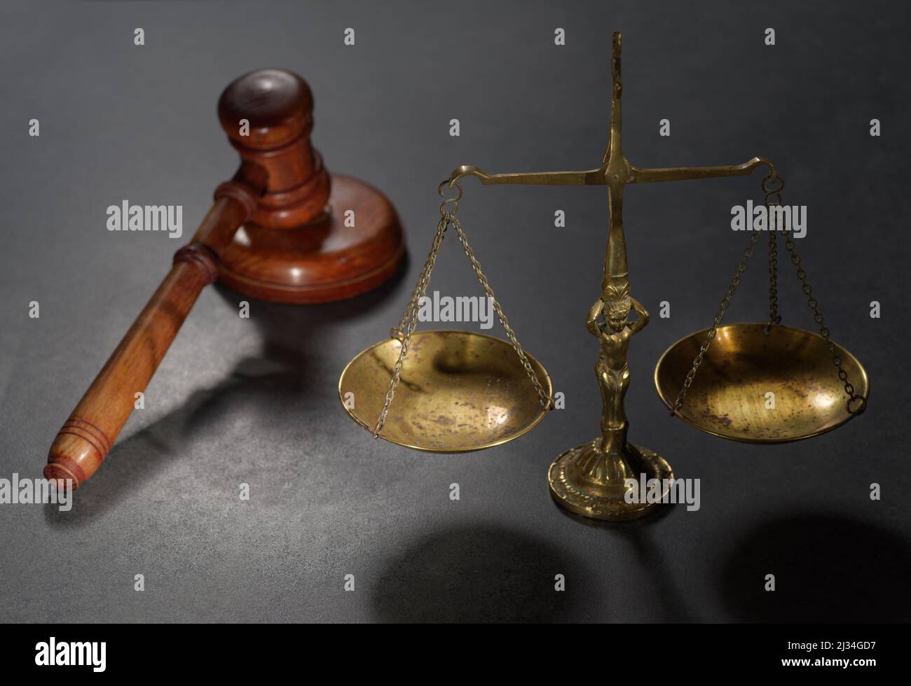 Hölzerne Richter gavel und Symbol für Recht und Gerechtigkeit auf dem Tisch in einem Gerichtssaal oder Strafverfolgungsbehörde auf dunklem Hintergrund Stockfoto