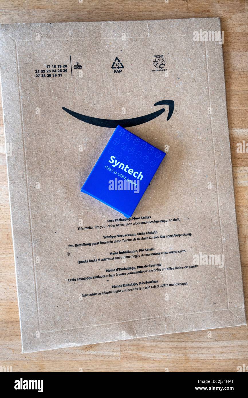 Kleine blaue Schachtel, die von Amazon geliefert wird, in einem großen Pappumschlag. Stockfoto