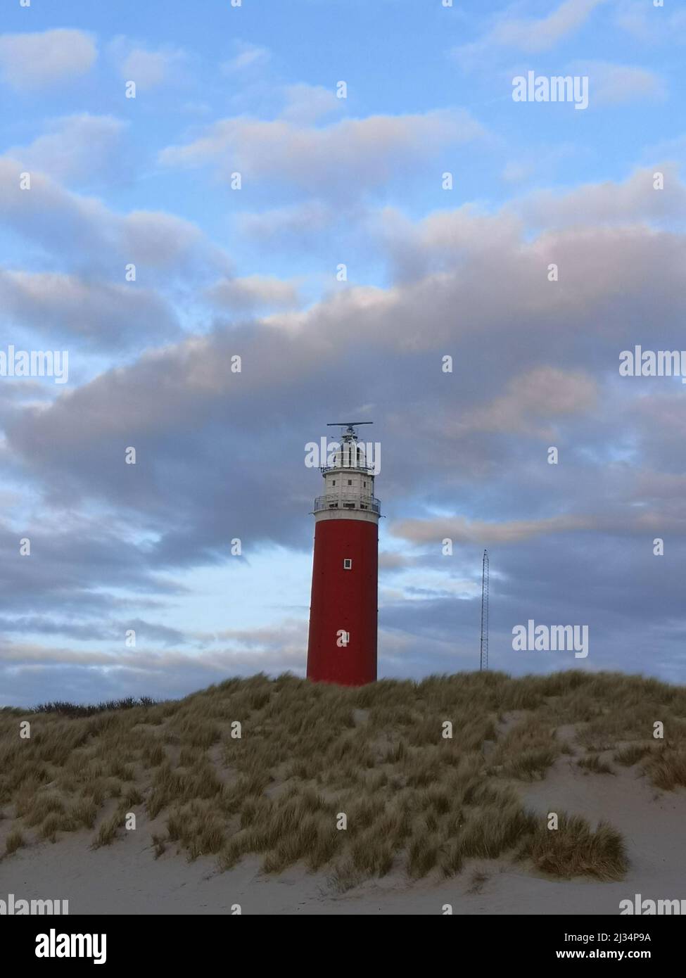 Der Leuchtturm von De Cocksdorp von Texel, aus nächster Nähe mit einem bunten bewölkten Himmel. Stockfoto