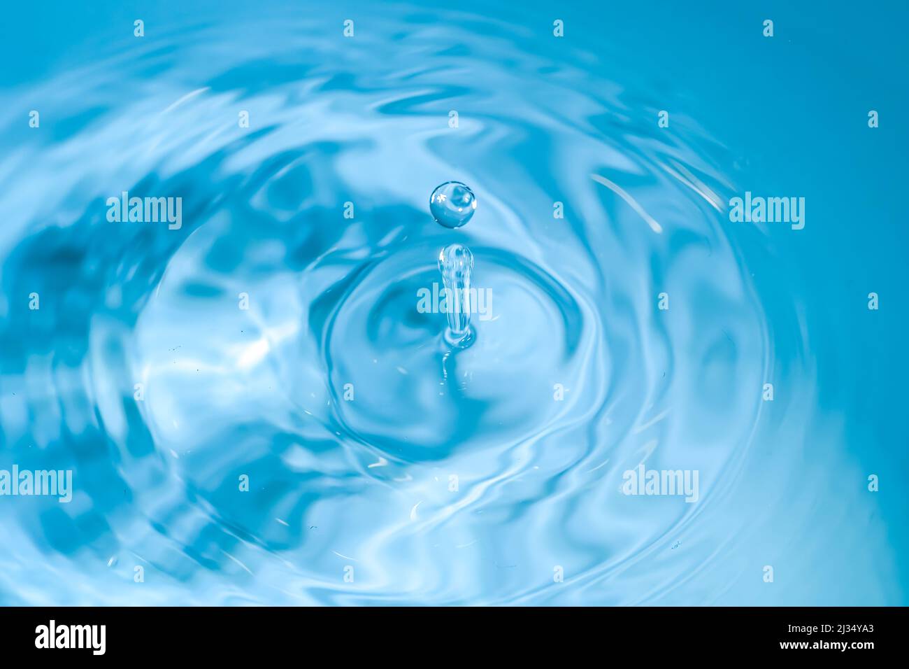 Wassertropfen, blau gefärbt. Runder Wassertropfen. Wassertropfen im Glas. Tropfen, Spritzer, Spray, abstrakte Formen aus dem Wasser Stockfoto