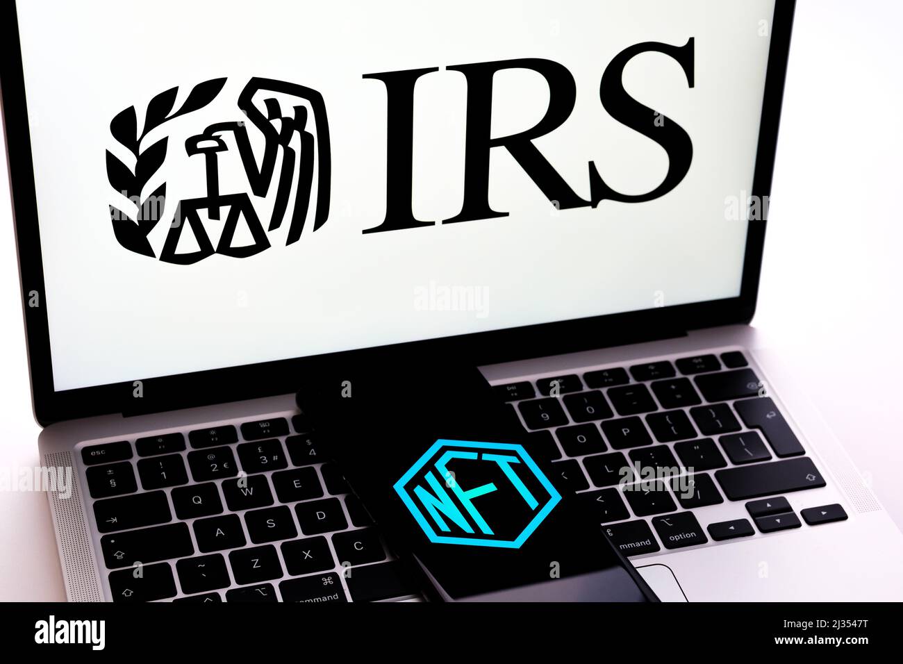 NFT-Logo auf dem Smartphone auf der Laptop-Tastatur mit IRS-Logo. Selektiver Fokus. Konzept. Stafford, Großbritannien, 5. April 2022 Stockfoto