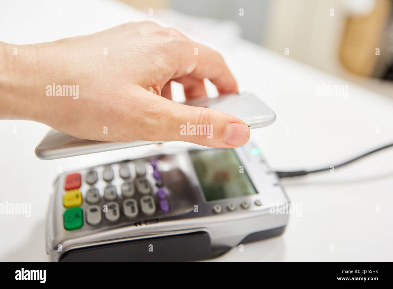 Kontaktloses Bezahlen als Service im Handel mit Smartphone-App und NFC-Reader Stockfoto