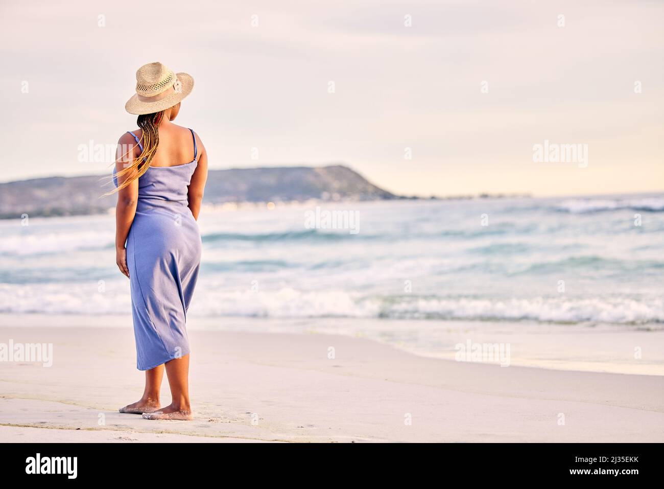 Ich blieb in Vergessenheit stecken. Rückansicht einer nicht erkennbaren Frau, die am Strand entlang läuft. Stockfoto