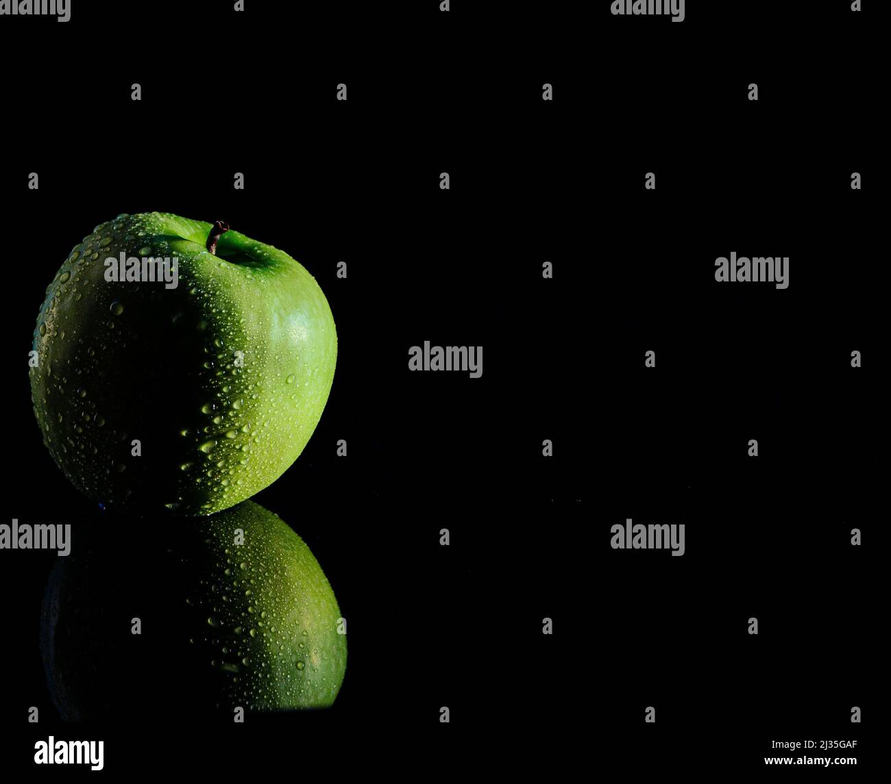 Low-Key-Fotografie eines grünen Apfels Stockfoto