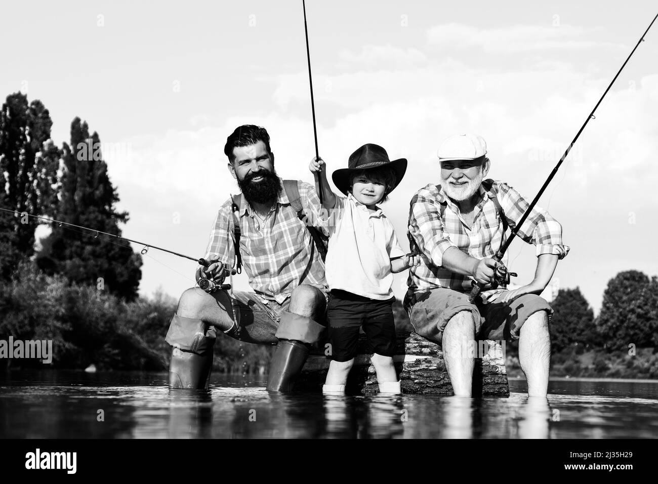 Großvater, Vater und Sohn fischen auf dem Fluss. Stockfoto
