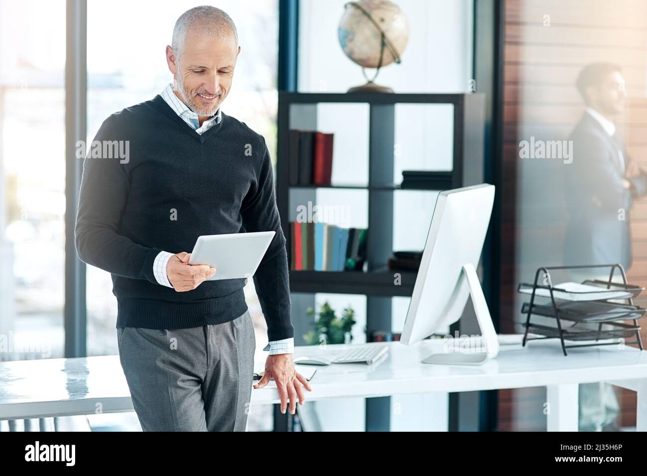 Ich achte auf Kundenfeedback, um mein Unternehmen zu verbessern. Aufnahme eines reifen Geschäftsmannes, der sein digitales Tablet im Büro verwendet. Stockfoto