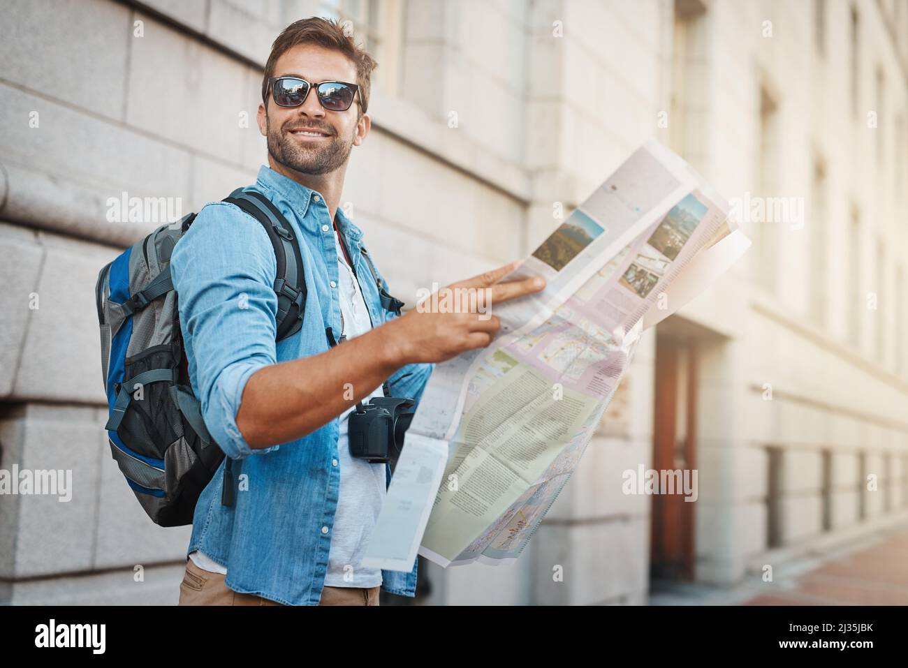 Ich war nicht in einem Hotel. Aufnahme eines jungen Mannes, der während einer Tour durch eine fremde Stadt auf eine Karte schaute. Stockfoto