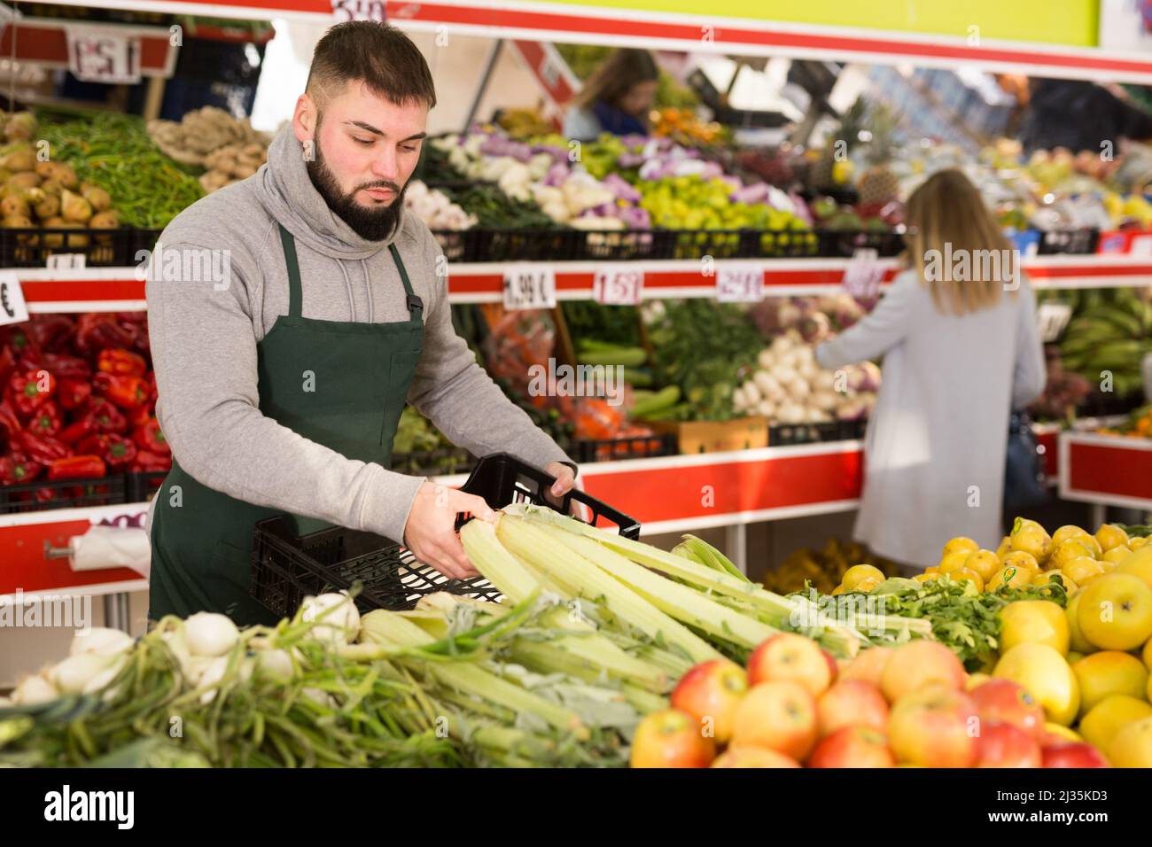 Einkaufsassistent legt Gemüse und Obst an die Theke des Supermarkts Stockfoto