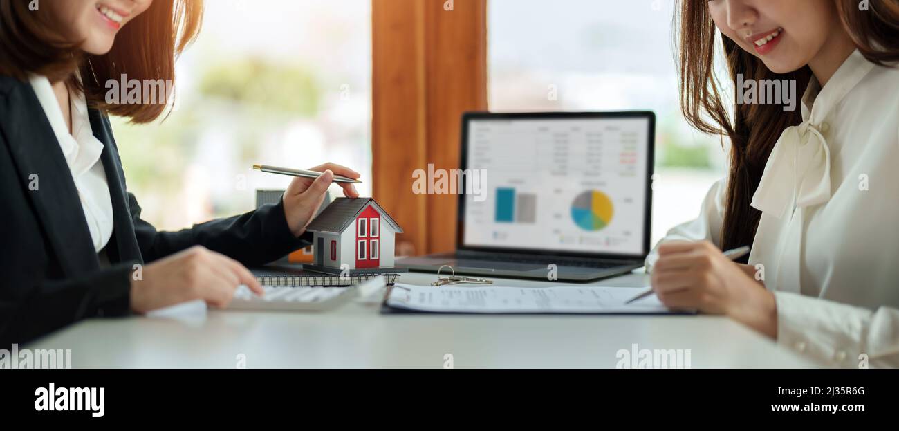 Immobilienmakler oder Bankkaufmann beschreibt die Darlehenszinsen an den Kunden mit Hauskaufverträgen oder auf Bürokredite und Zinssätze Stockfoto