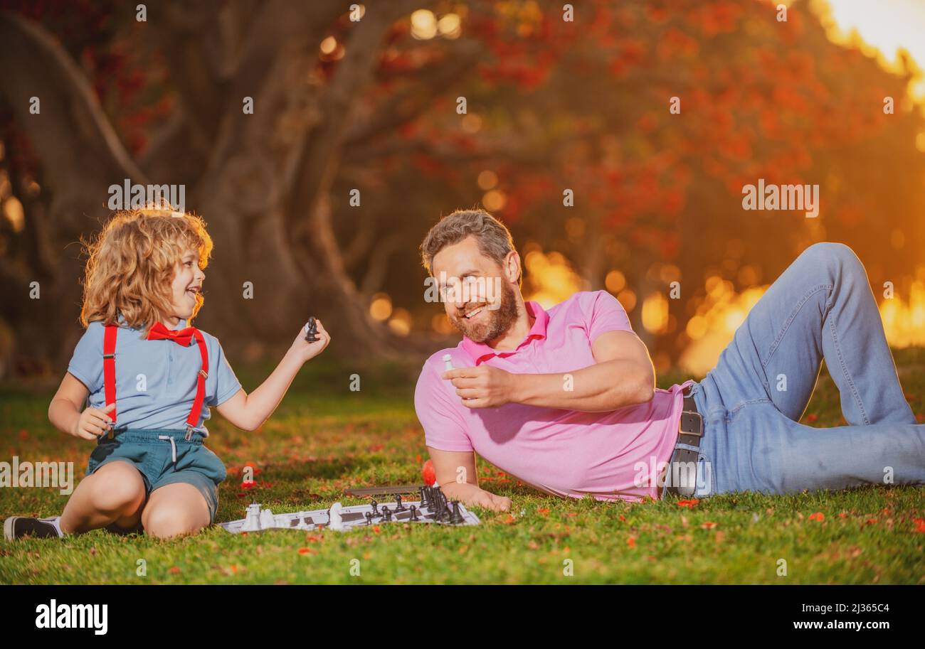 Vater spielt Schach mit Sohn. Familie draußen Spiel. Intelligentes Kind, intelligente Kinder. Stockfoto