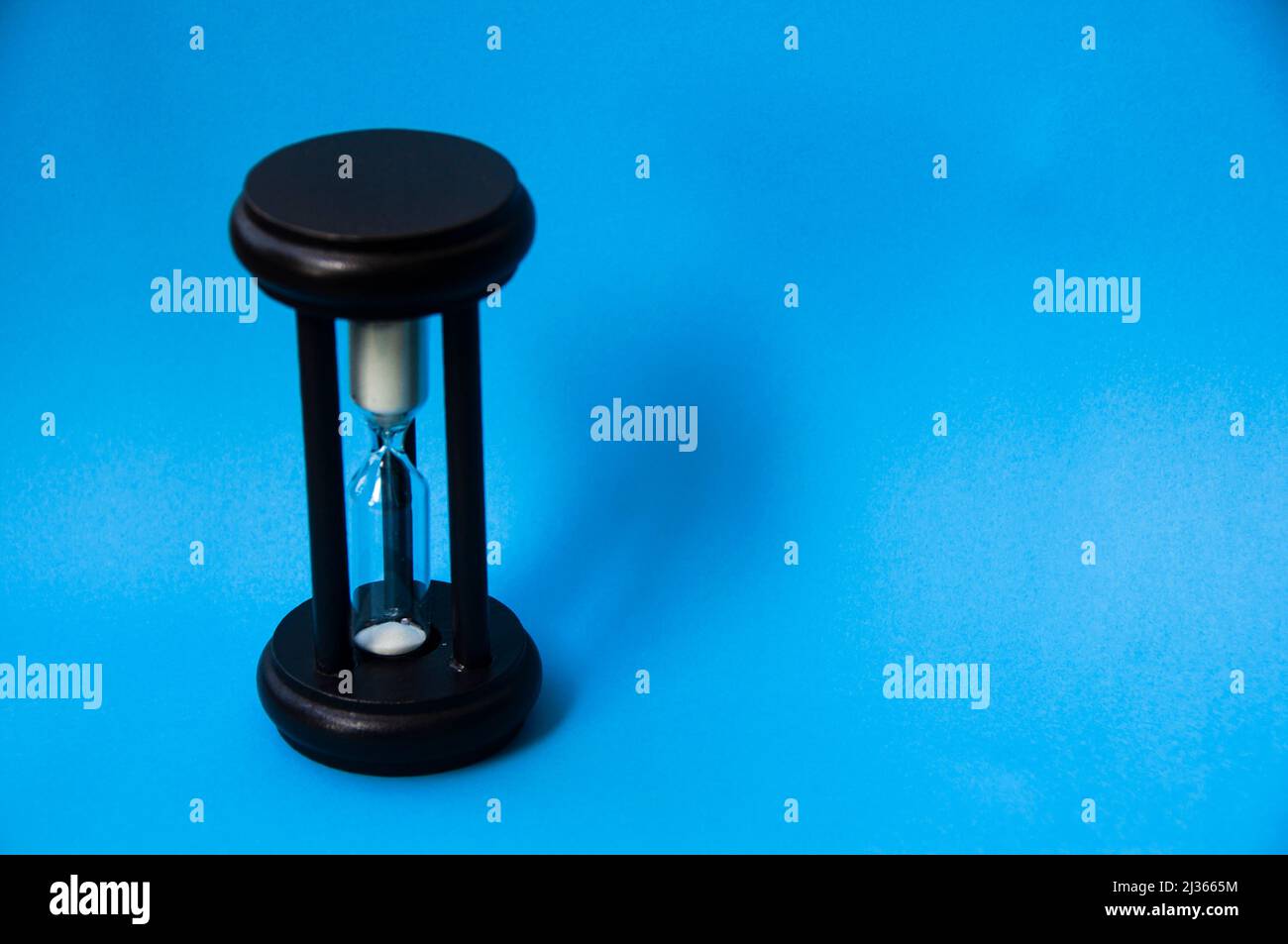 Minutenglas auf hellblauem Hintergrund isoliert. Speicherplatz kopieren. Stockfoto
