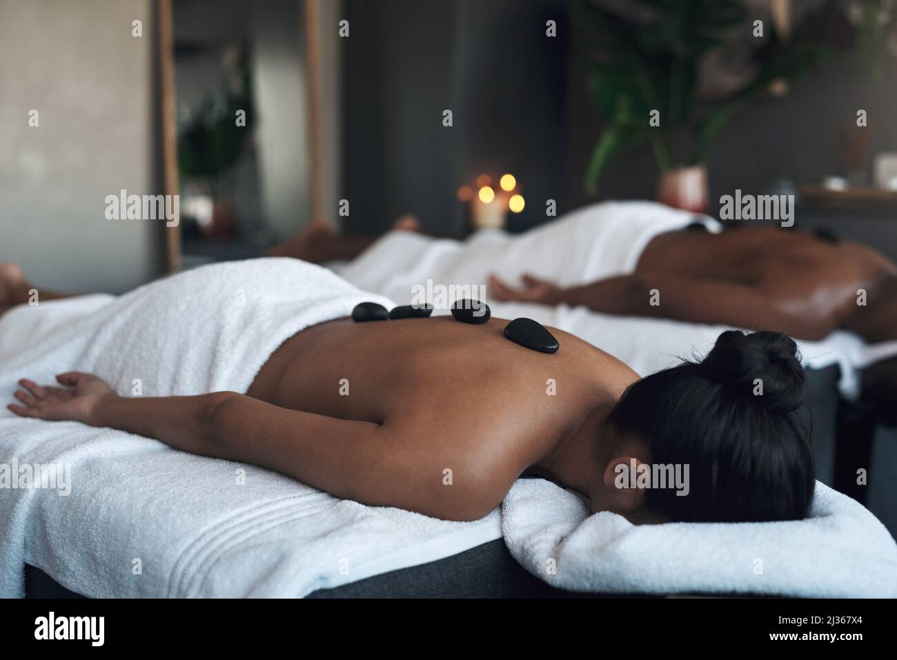 Es gibt kein besseres Gefühl als eine Tiefenmassage. Aufnahme einer jungen Frau, die in einem Spa eine Hot-Stone-Massage bekommt. Stockfoto