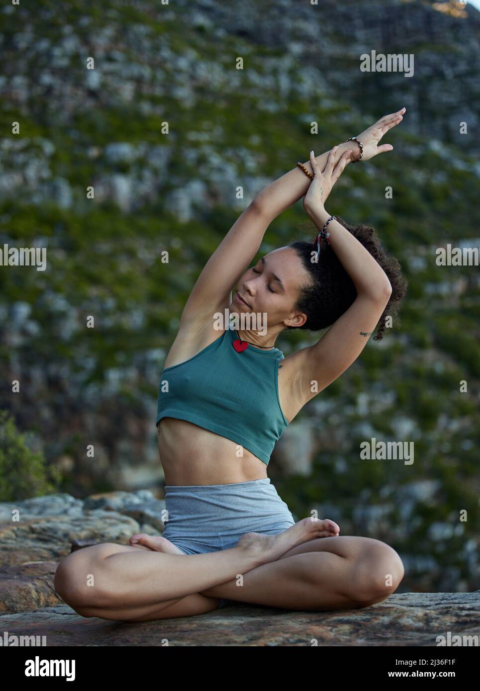 Yoga lässt dich die Dinge anders betrachten. Aufnahme einer jungen Frau, die Yoga praktiziert, während sie in den Bergen unterwegs ist. Stockfoto