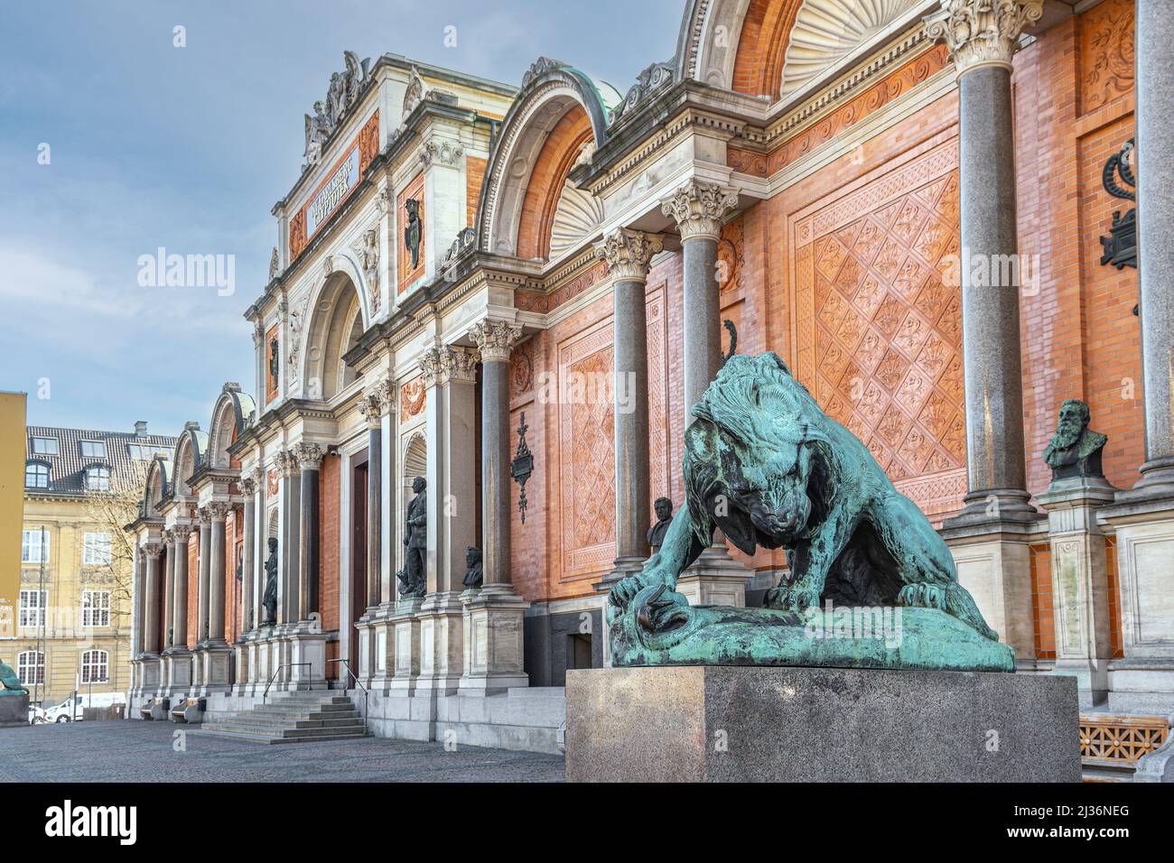 Fassade des Museums, NY Carlsberg Glyptotek, der bildenden Kunst, im Vordergrund die Bronzestatue eines Löwen, der eine Schlange angreift. Kopenhagen, Dänemark Stockfoto