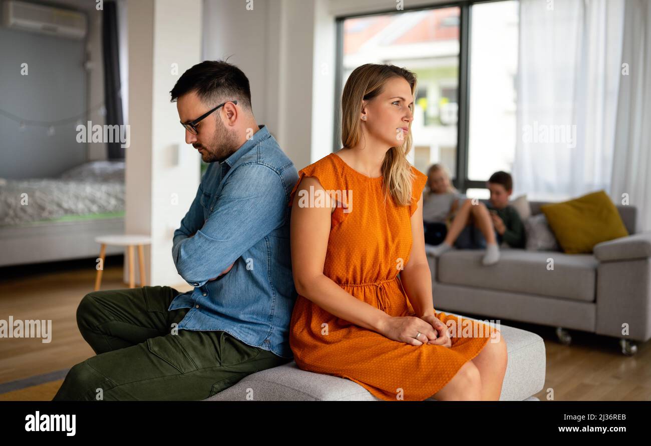 Traurige, nachdenkliche Paare, die an Beziehungsprobleme denken, die auf dem Sofa sitzen, Konflikte in der Ehe. Stockfoto