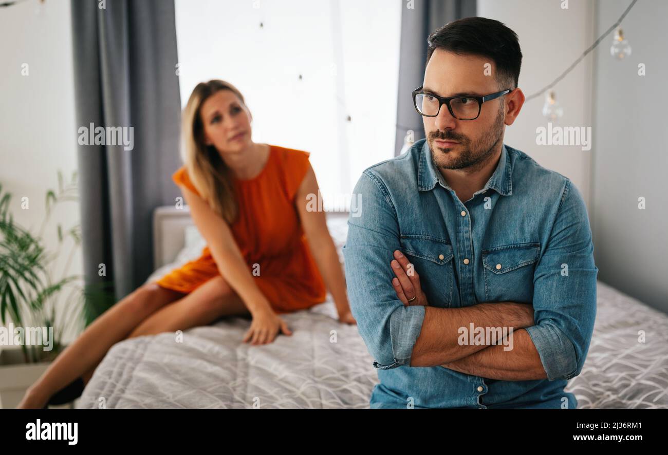 Traurige, nachdenkliche Paare, die an Beziehungsprobleme denken, die auf dem Sofa sitzen, Konflikte in der Ehe. Stockfoto