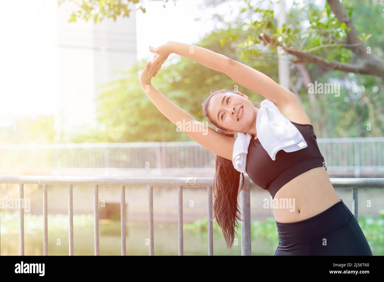 Asiatische gesunde Frau Schulter Stretching Übung im Freien Morgen Stockfoto