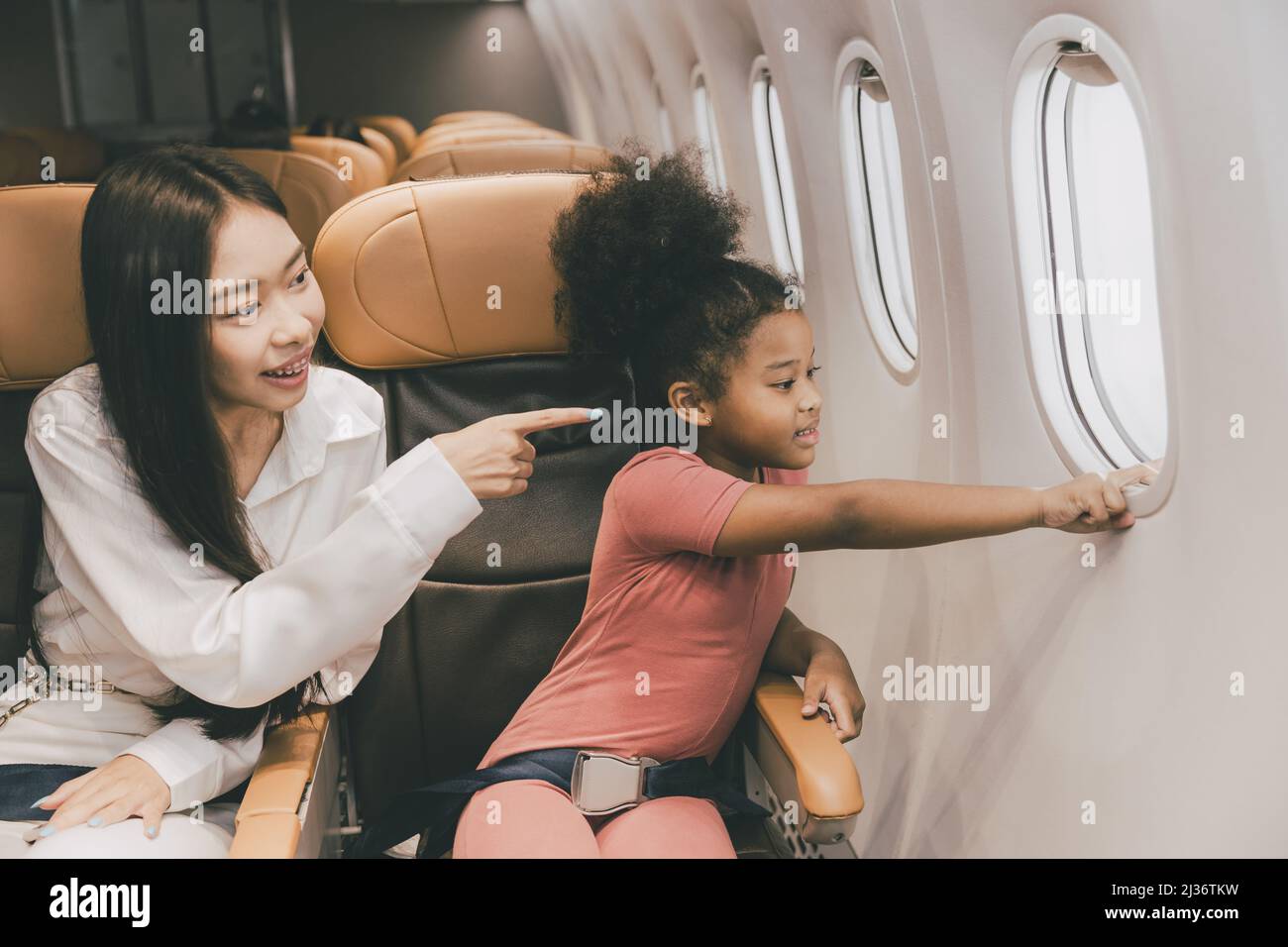 Menschen mit Kind glücklich aussehende Fenster während Flug Urlaub Reise Stockfoto