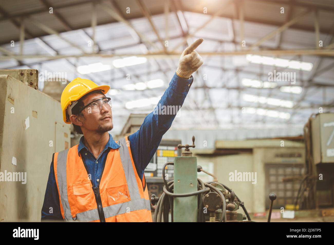 Ingenieur Woker in der Fabrik Hand steigt. Asiatisches Personal, das auf ein zukünftiges Konzept hinweist. Stockfoto