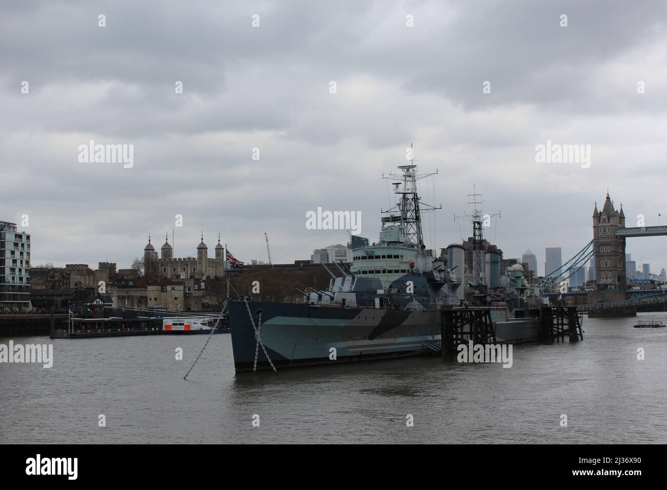HMS Belfast an der Themse und dem Tower of London Building in der Ferne in London Stockfoto