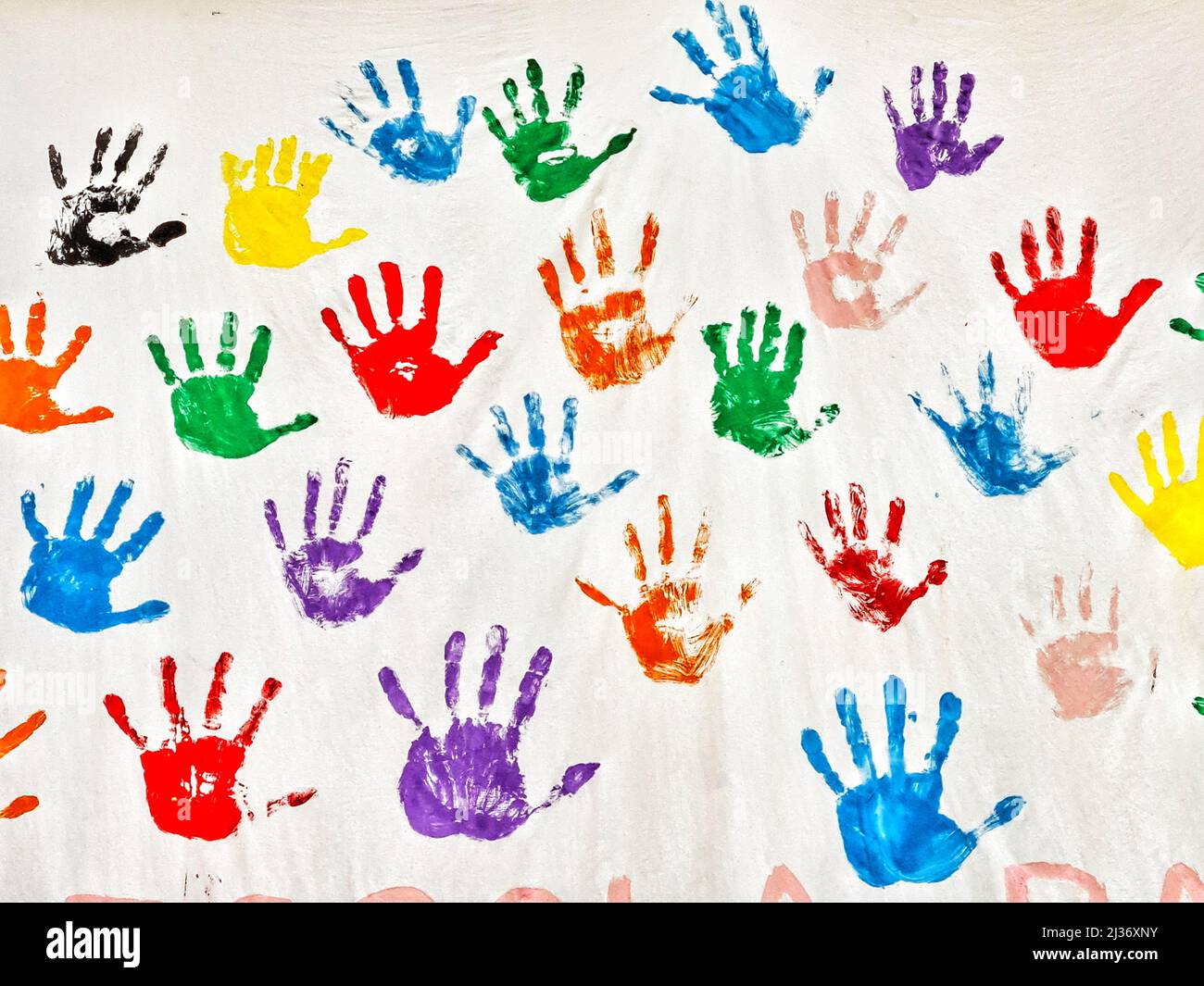Farbige Hände für Kinder, gestempelt an einer weißen Wand. Stockfoto