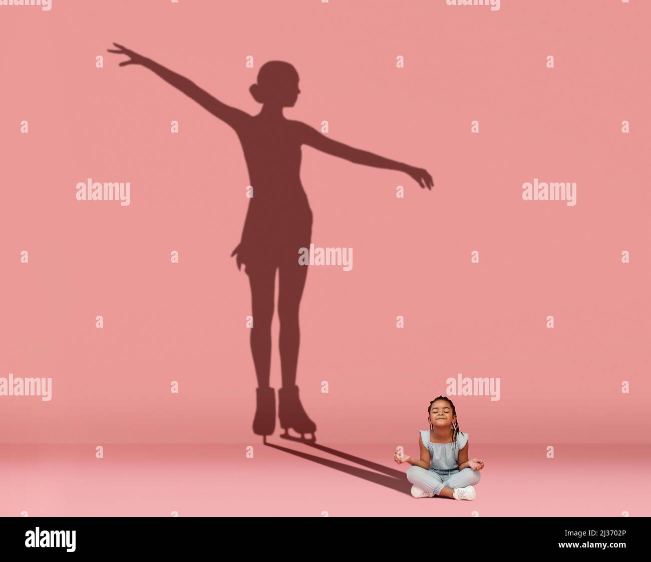 Kleines glückliches Mädchen, das auf dem Boden sitzt und davon träumt, Eiskunstläuferin zu werden, isoliert auf rosa Hintergrund. Sport, Karriere und Träume Konzept. Collage Stockfoto