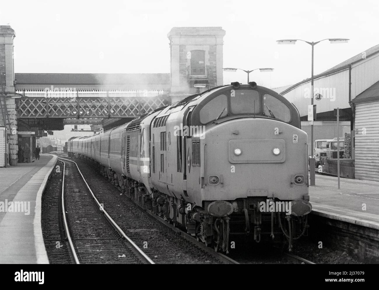 Eine Diesellokomotive der Baureihe 37 mit der Nummer 37142, die eine ausgefallene HST mit Bleikraft 43175 schleppt, arbeitete am 23.. November 1991 in Exeter St Davids als InterCity-Lokomotive. Stockfoto