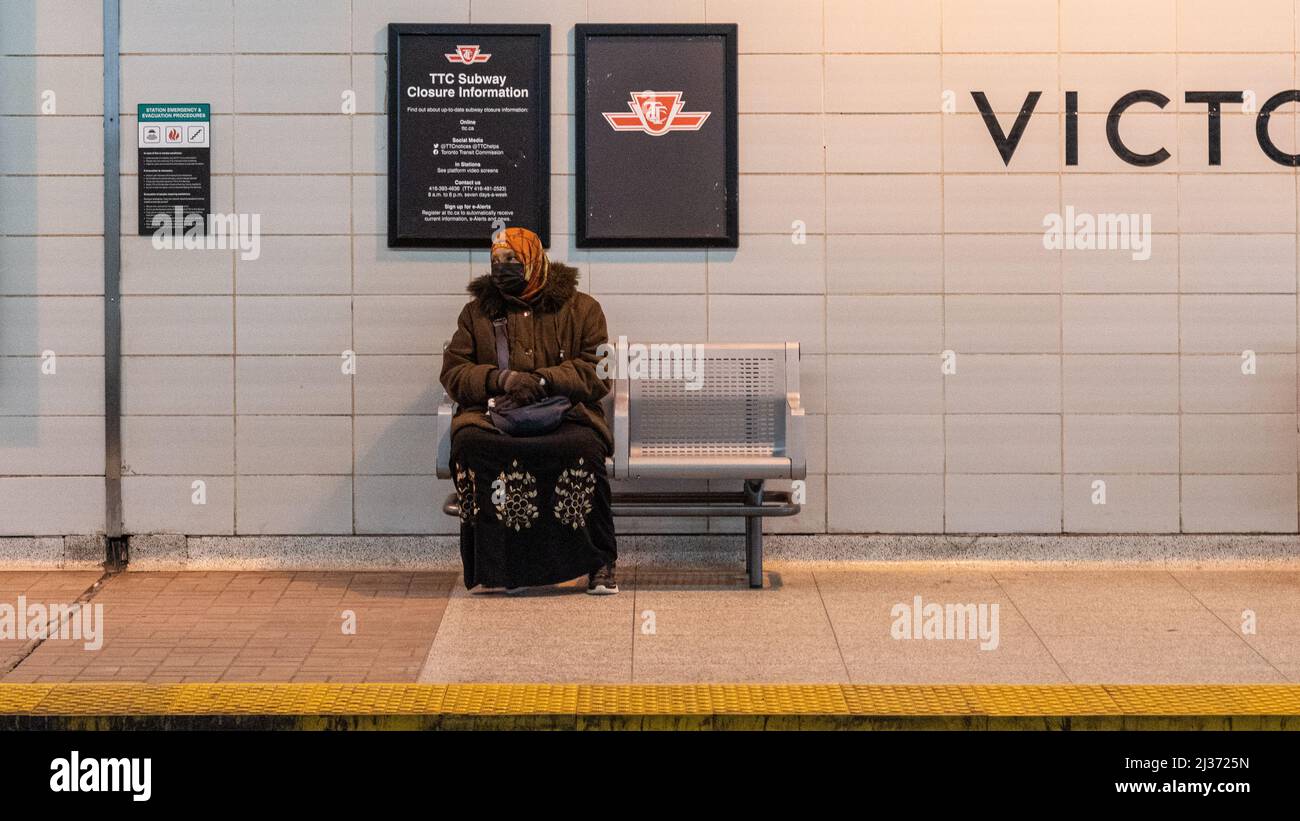 Eine muslimische Frau sitzt auf einer Bank und wartet auf einen TTC-U-Bahn-Zug auf dem Bahnsteig der Victoria Park U-Bahn-Station. Nahaufnahme. Die Toronto Transit Commission ist Stockfoto