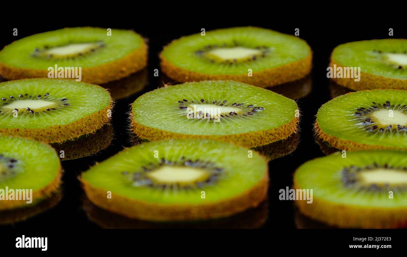 Kiwi-Fruchtscheiben auf schwarzem Hintergrund in. Nahaufnahme von frischen und leckeren Kiwi, Studioaufnahme. Stockfoto