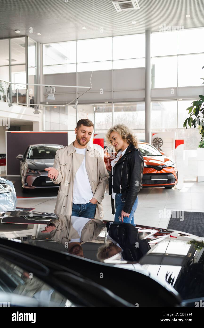 Schönes junges Paar in einem Autohaus wählen Sie ein Auto Stockfoto
