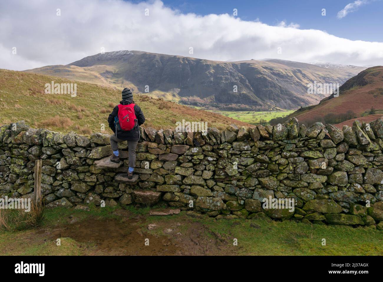 Eine Frau stand auf einer Treppe in einer Trockensteinmauer am Low Rigg und schaute auf den Blick von Clough Head und St. Johns im Vale im English Lake District National Park, Cumbria, England. Stockfoto