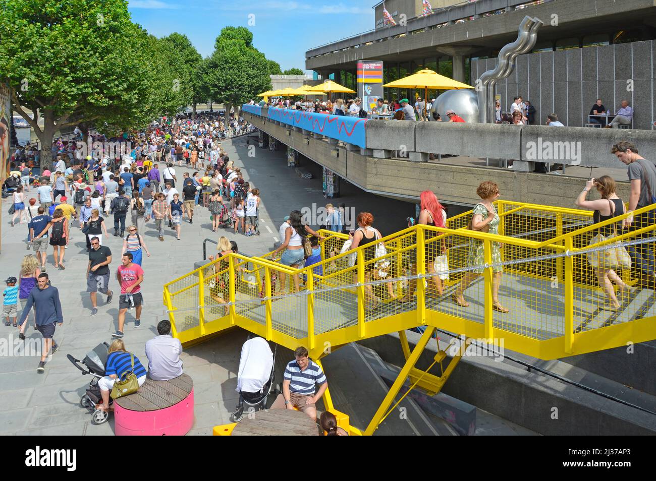 Besucher und Touristen bei Sommersonne auf einem überfüllten Spaziergang am Flussufer im Southbank Centre, einem Komplex von Unterhaltungs- und Kunststätten in Lambeth London, Großbritannien Stockfoto
