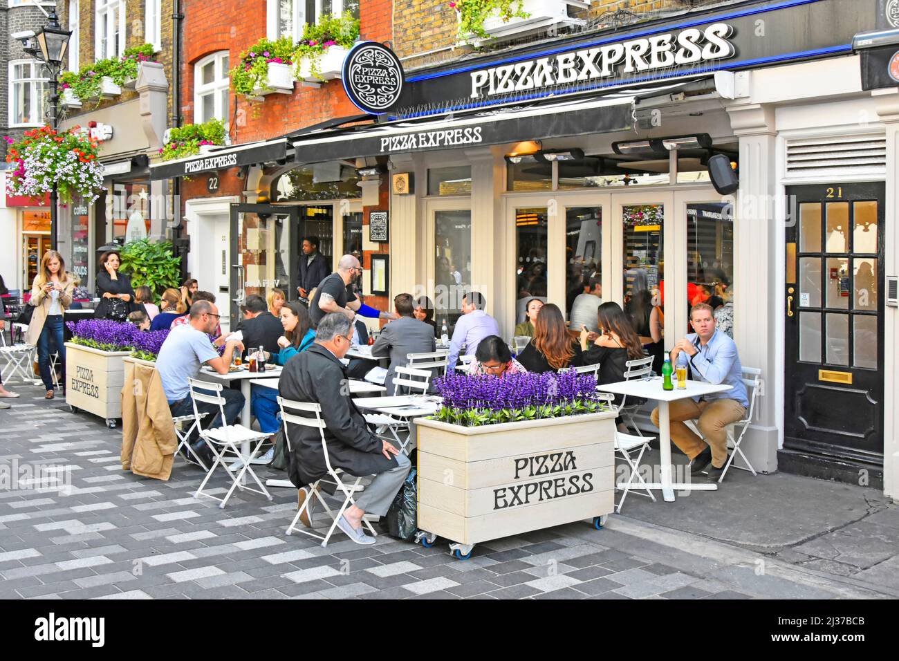 Gäste sitzen vor dem Pizza Express Restaurant, essen im verkehrsfreien St Christophers Place in der Nähe der Oxford Street, London West End, Großbritannien, draußen und essen im Freien Stockfoto