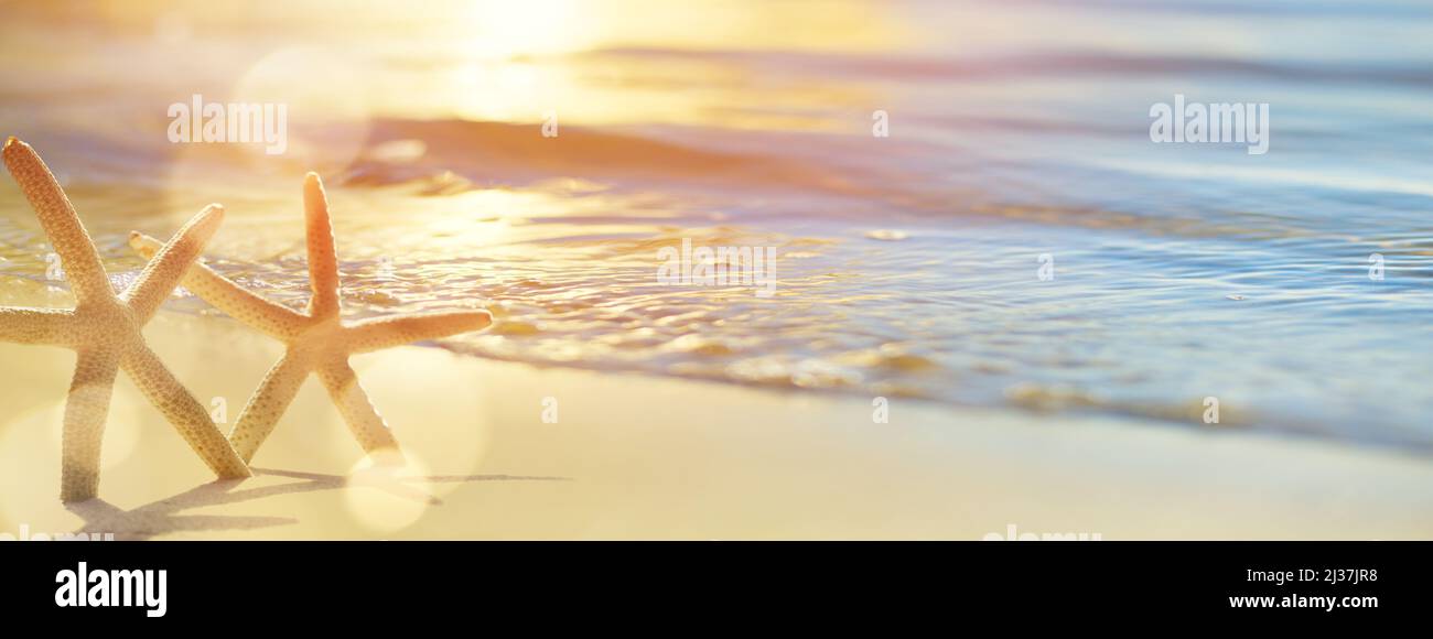 Abstrakt schöne verschwommene Sandstrände Sommerurlaub Hintergrund. Bokeh Sonnenuntergang Licht auf Sommer Meer Strand Stockfoto