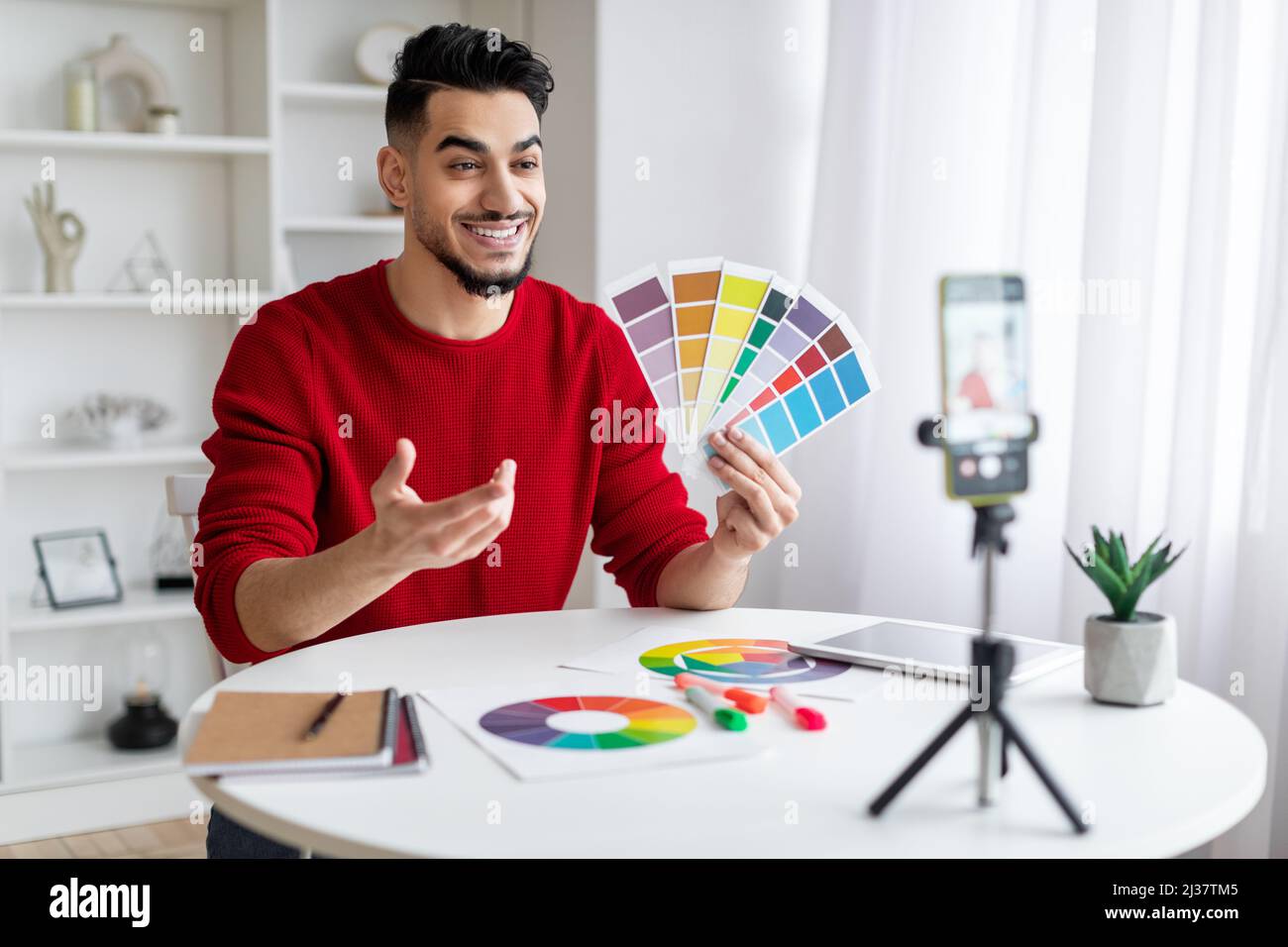 Tutoring-Konzept. Arabischer Grafikdesigner Demonstriert Farbfelder An Der Telefonkamera Stockfoto