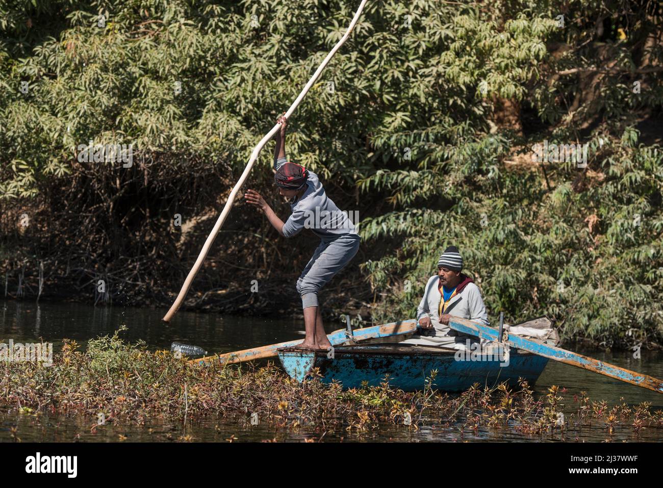 Netzfischer im Ruderboot üben eine Technik, die darin besteht, die Oberfläche des Wassers zu treffen, um die Fische in den Netzen zu treiben, Dorf Ramadi, Stockfoto