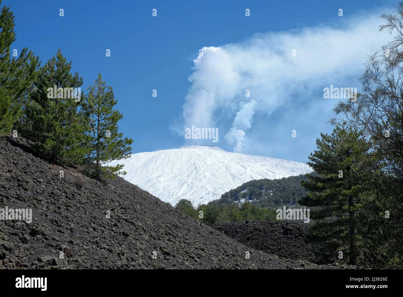 Zwei hohe, weiße Dampfwolken aus den Gipfelkrater des schneebedeckten Ätna-Berges auf Sizilien Stockfoto