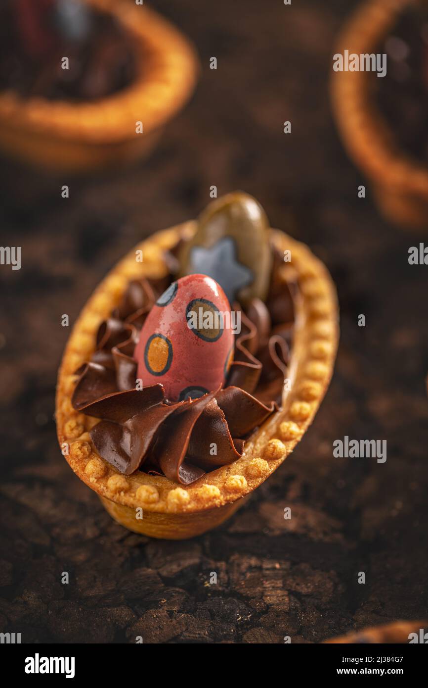 Köstliches Tartlets-Dessert mit Schokoladencreme-Füllung, verziert mit Mini-Osterschokolade-Eiern Stockfoto