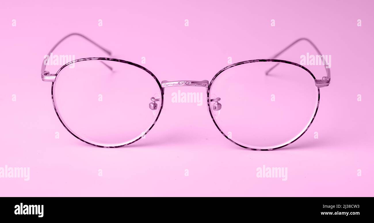 Frau trendige Brille mit runden Rahmen auf violett-violettem Hintergrund. Hochwertige Fotos Stockfoto