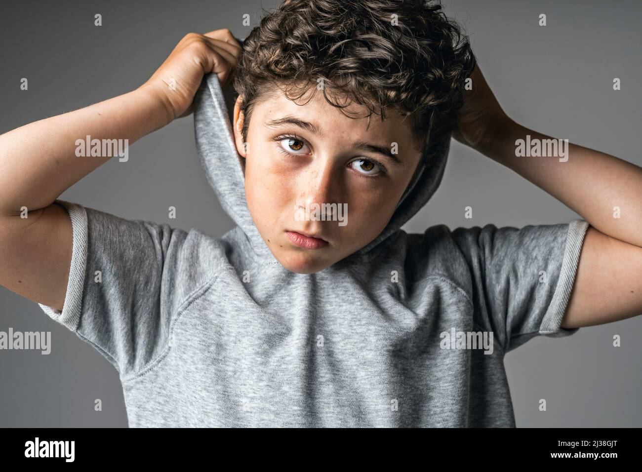 Portrait von jungen und niedlichen Teenager mit Hoodies auf Studio grau Stockfoto