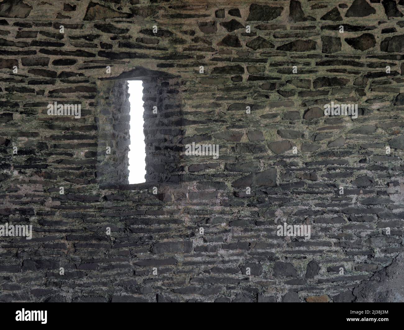 Pfeilspaltfenster im alten Steingebäude. Stockfoto