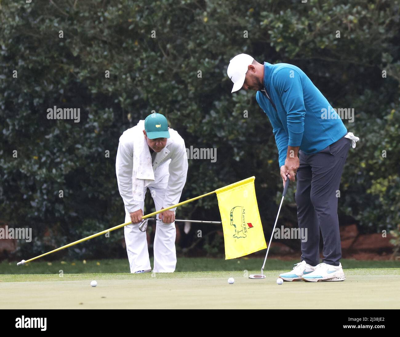 Augusta, Usa. 06. April 2022. Caddie Ricky Elliott beobachtet, wie Brooks Koepka am Mittwoch, den 6. April 2022, in einer Übungsrunde im Augusta National Golf Club in Augusta, Georgia, auf dem 11. Green puttet. Foto von John AngelilloUPI Kredit: UPI/Alamy Live Nachrichten Stockfoto