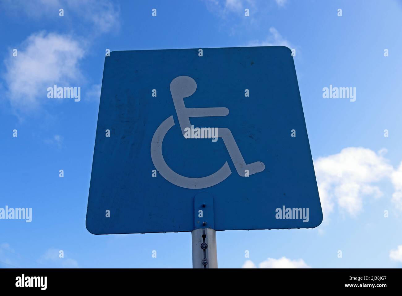 Blau und weiß Behindertenschild gegen blauen Himmel Stockfoto