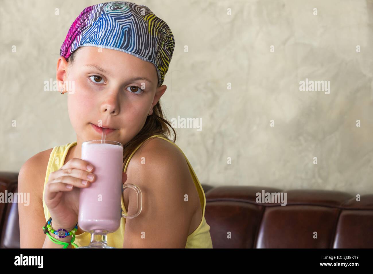 Glückliches kleines Mädchen trinkt rosa Erdbeer-Milchshake, Nahaufnahme Porträt Stockfoto