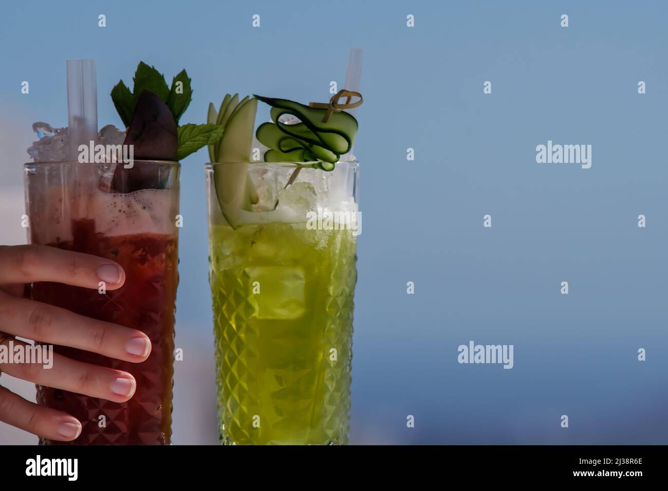 Nahaufnahme von zwei farbenfrohen und köstlichen Cocktails auf blauem Hintergrund Stockfoto
