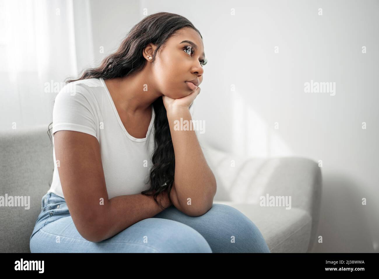 Gestresste miserable schwarze Frau leiden unter Trauer Problem, depressive einsam verärgert afrikanisches Mädchen weinen allein auf dem Sofa Stockfoto
