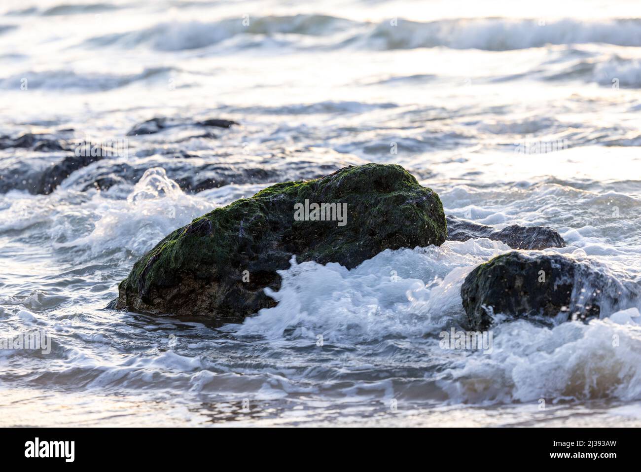 Leichte Wellen mit etwas weißem Schaum und kleinen bubles auf einigen ziemlich großen Felsen, am Ufer des Cap Blanc-Nez, Frankreich. Hochwertige Fotos Stockfoto