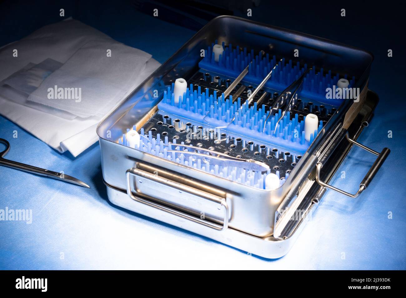 Offene Box mit sterilen Instrumenten für die Katarakt-Chirurgie auf einem Operationstisch mit blauen sterilen Vorhängen. Pinzette, Gaze, Hämostatik, Schere, Hilfsmittel Stockfoto