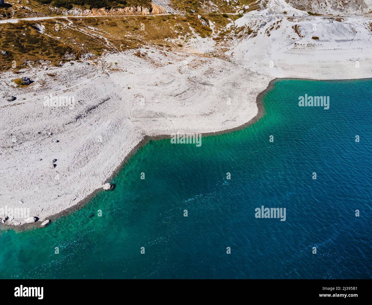 Eine Luftaufnahme von grünen Hügeln am Ufer des blauen Wassers in Luenersee, Ostalpen, Österreich Stockfoto